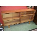 A teak office cabinet, two pairs of sliding glass doors enclosing shelving. c.