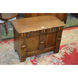 A rustic oak blanket box of small proportions, hinged top, two panels,