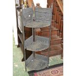 A copper three tier folding plant stand embossed with scenes of elephants on the Serengeti.