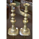 A pair of early 19th century brass candlesticks with pushers,