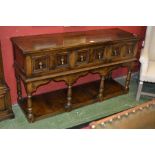 An oak country sideboard, moulded top, three drawers pendant handles, shaped apron, turned supports,