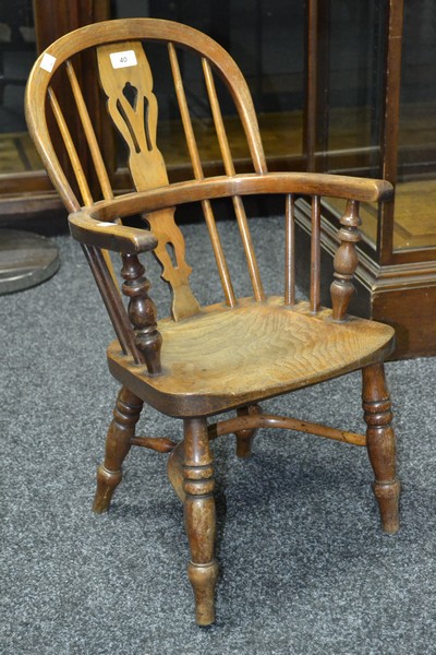 An elm child's Windsor chair, hooped back, pierced splat, turned supports, crinoline stretcher.