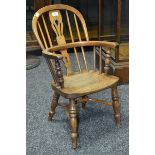 An elm child's Windsor chair, hooped back, pierced splat, turned supports, crinoline stretcher.