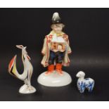 A Herend figure of a boy holding a nativity scene, wearing a pointed hat and cape, domed base,