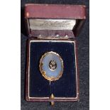 A Victorian gold framed milky agate brooch, centre with diamond set flower on enamel panel,