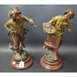 A pair of spelter figures of girl and boy fruit pickers.