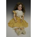 A Schoenau & Hoffmeister bisque head doll, fixed brown eyes,