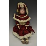 A German bisque head doll, sleeping brown glass eyes, open red lips revealing four large top teeth,