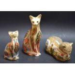 A Royal Crown Derby paperweight Siamese cat; a kitten similar; a contented cat,