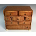 A Continental miniature chest, flush top above an idiosyncratic arrangement of eight drawers,