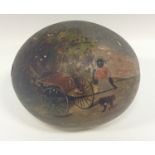 A 19th century Colonial painted ostrich egg, decorated with a negro woman at the shaft of gig,