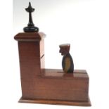 A folk art mahogany and painted folk art counter balance money box, turned ebonised finial,