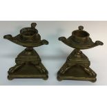 A pair of post-Regency bronze tripod pricket candlesticks, cast as lamps in the Roman taste,