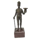 A 19th century patinated bronze figural taperstick, as a Renaissance knight in armour,