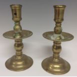 A pair of Dutch brass heemskerk candlesticks, cylindrical sconces, broad drip pans, knopped stems,
