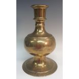 A large Persian brass baluster candlestick, cylindrical sconce,