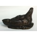 A Regency dark patinated bronze inkwell, cast as a swan, with neck craned to wing,