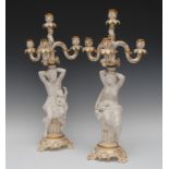 A pair of Minton Parian and porcelain figural candelabra, three-branch, four light scroll arms,