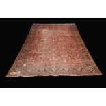 A large middle eastern woollen carpet floral design in tones of brown, grey and faun,