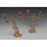 A pair of silver and silver gilt two-light, two-branch table candleabra, in the Rococo manner,