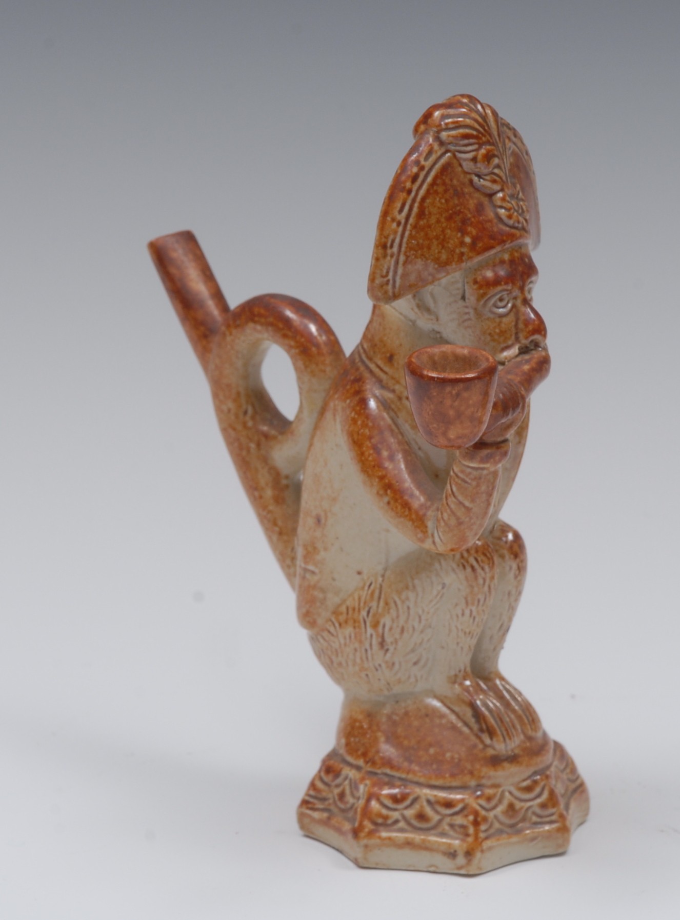 A 19th century brown salt glazed novelty pipe, moulded with monkey, crouching,