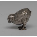 An early 20th century silver coloured metal novelty pepper, as a chick, screw-fitting cover,