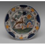 A Dutch Delft circular plate, painted in polychrome with stag leaping, fence and stylised foliage,