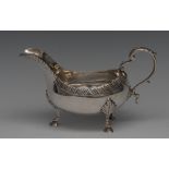 An early George III silver sauce boat, gadrooned rim, acanthus capped flying scroll handle,