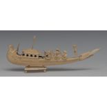 An Indian ivory model of a boat, the hull carved as a peacock, rowers on deck, 20cm long,