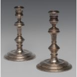 A pair of George II style silver candlesticks, reel shaped sconces, knopped columns,