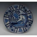 A Dutch Delft circular charger, painted in underglaze blue with peacock and foliage,