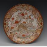 A Japanese Kutani charger, decorated with quails and flowers and foliage, in tones of orange,