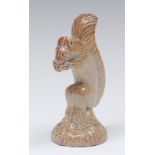 A Brampton brown salt glazed stoneware model of a squirrel, eating a nut, circular leafy base, 9.