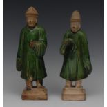 A pair of Chinese Ming style pottery figures, of attendants, standing, green glaze,