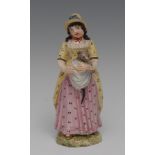 A Naples figures, she stands holding a cat in her apron,