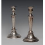 A pair of silver candlesticks, detachable nozzles, campana shaped sconces, tapering columns,