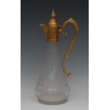 An early 20th century gold plated and clear glass claret jug, engraved with scrolls and swags,