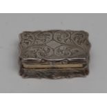 An early Victorian silver shaped rectangular vinaigrette, engraved overall with scrolling foliage,