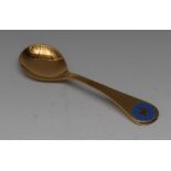 Georg Jensen - a silver-gilt and enamel spoon, the terminal decorated in tones of blue,