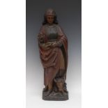 A post-Medieval polychrome carving, of a saint, she stands, dressed in a long robe,