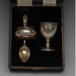 A George V silver christening set, comprising egg cup, spoon and napkin ring, the egg cup 6cm high,