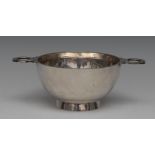 A George V silver porringer, of 17th century form, shaped lug handles, spreading foot, 18cm wide,