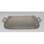 A George V silver rounded rectangular serving tray, plain field, fluted border, scroll handles,