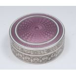 An early 20th century silver and puce enamel circular snuff box,