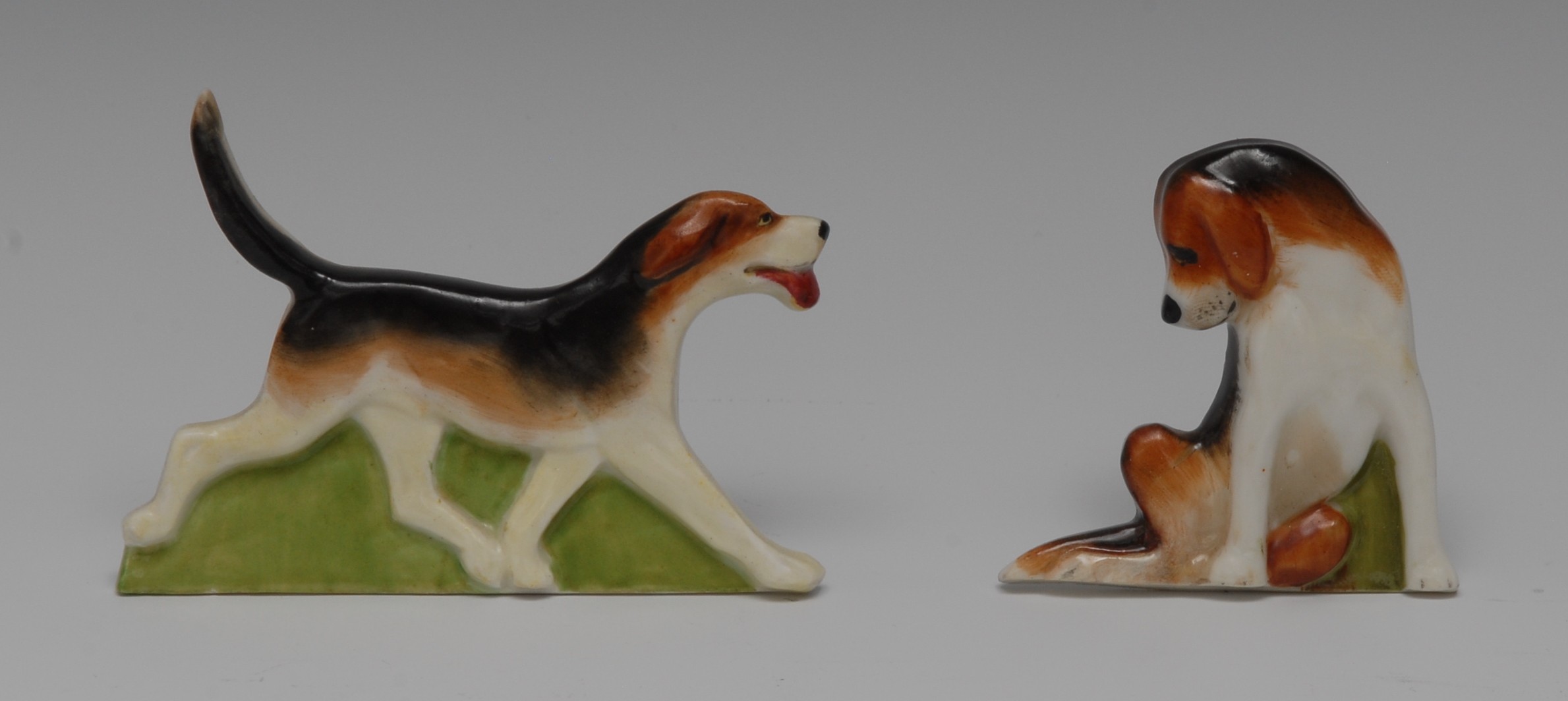 A pair of Royal Worcester Hunting menu holders, of fox hounds, one standing, the other seated,