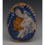An 18th century Delft oval plaque, in relief with Madonna and Child, in mustard and blue, 19cm high,