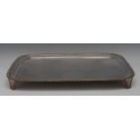 A large rounded silver serving tray, plain field, gadrooned rim, scroll feet, 55.