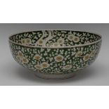 A large Chinese circular bowl, decorated with blossoming prunus on green ground, 31cm diam,