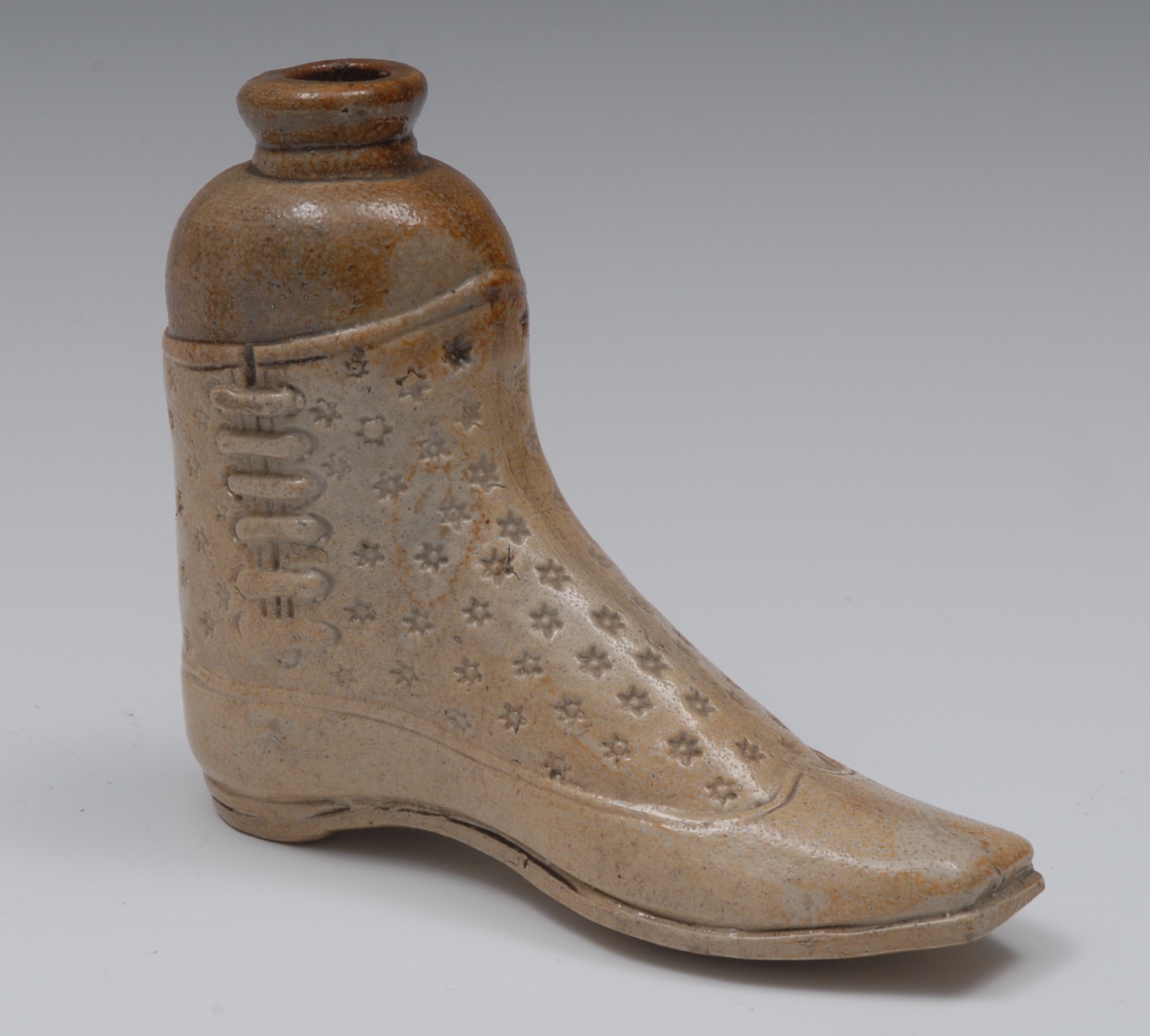 A 19th century brown salt glazed stoneware gin flask, in the form of a boot, impressed with stars,