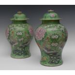 A pair of Chinese temple jars and covers, decorated with phoenixes, magnolia and peonies in pink,